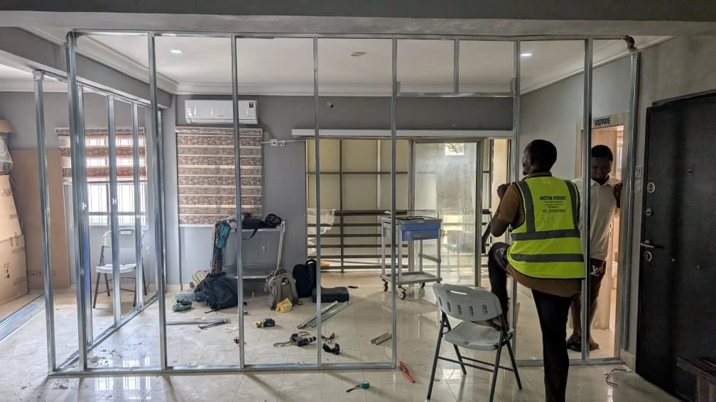 Site personnel installing interior partition framing during active construction